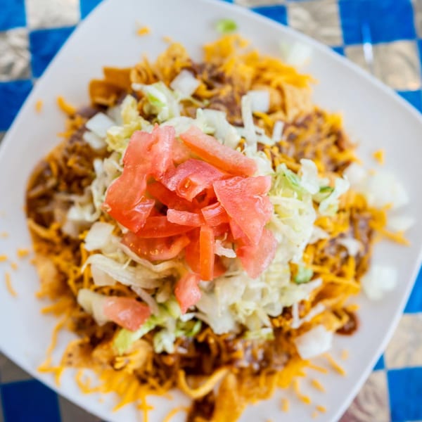 Barnett's Dairyette Frito pie topped with chili, cheese, lettuce, tomatoes, and onions.